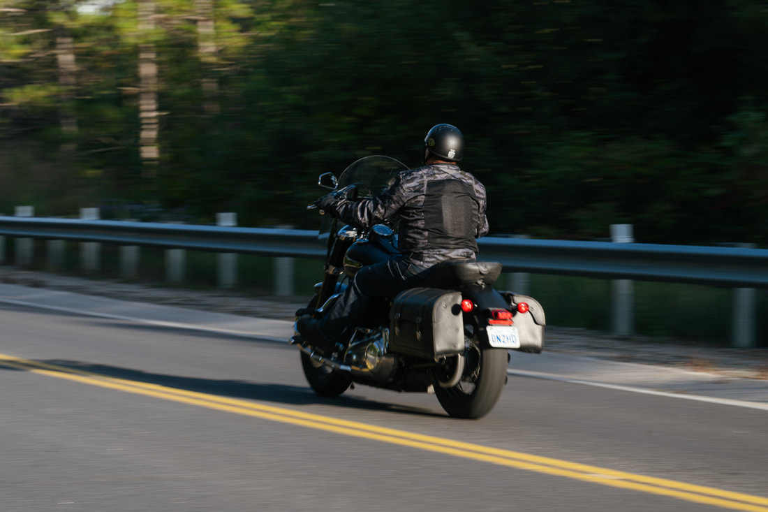 Man riding away on a motorcycle wearing a gryphon motorcycle jacket