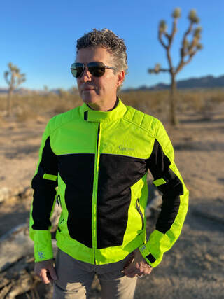man standing in the desert wearing a gryphon protective motorcycle jacket and sunglasses 